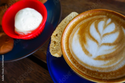 close up of a cup of cappuccino with a slice of bread