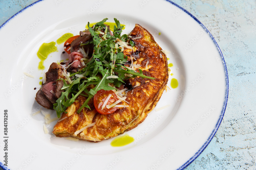omelet with beef slices and arugula on a plate omelet with beef slices and arugula on a plate