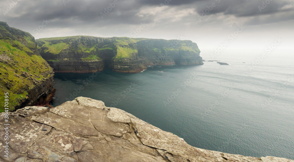 View on epic landscape of Cliff of Moher, county Clare, Ireland, Cloudy sky, Green grass. Nobody. Popular tourist destination