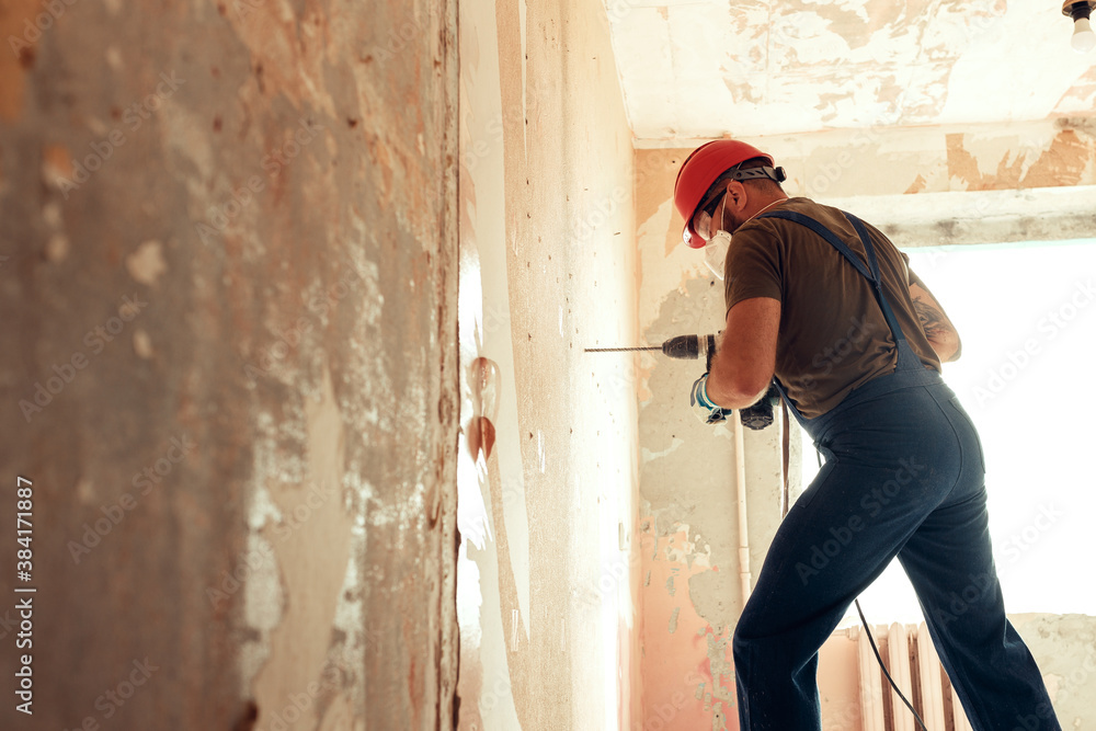 builder with perforator drills holes in concrete wall builder with perforator drills holes in concrete wall