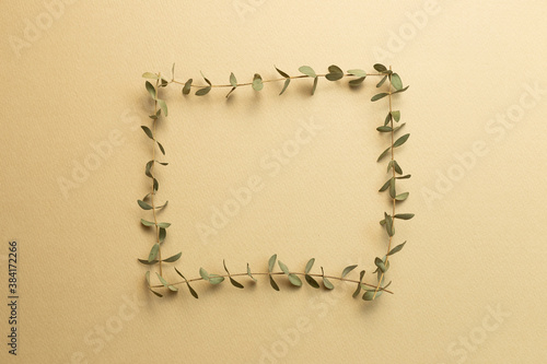 Beige blank paper with eucalyptus leaves decoration. flat lay, top view, copy space