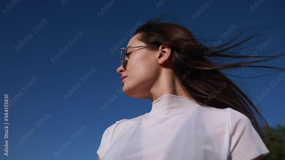 Portrait of woman with fluttering hair against sky. Portrait of woman with fluttering hair against sky.