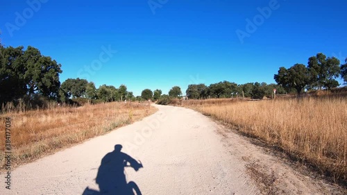 dolly move forward - shadow of a touring cyclist riding on a rural dirt road next to Flor da Rosa village, municipality of Crato, Portalegre district, Alentejo, Portugal photo