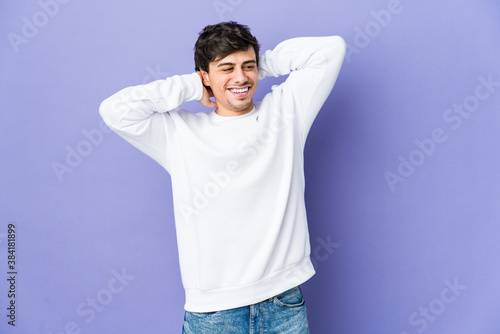 Young cool man feeling confident, with hands behind the head.