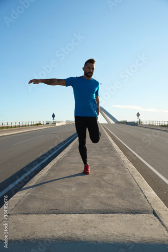 Runner doing body stretches to start his morning training.