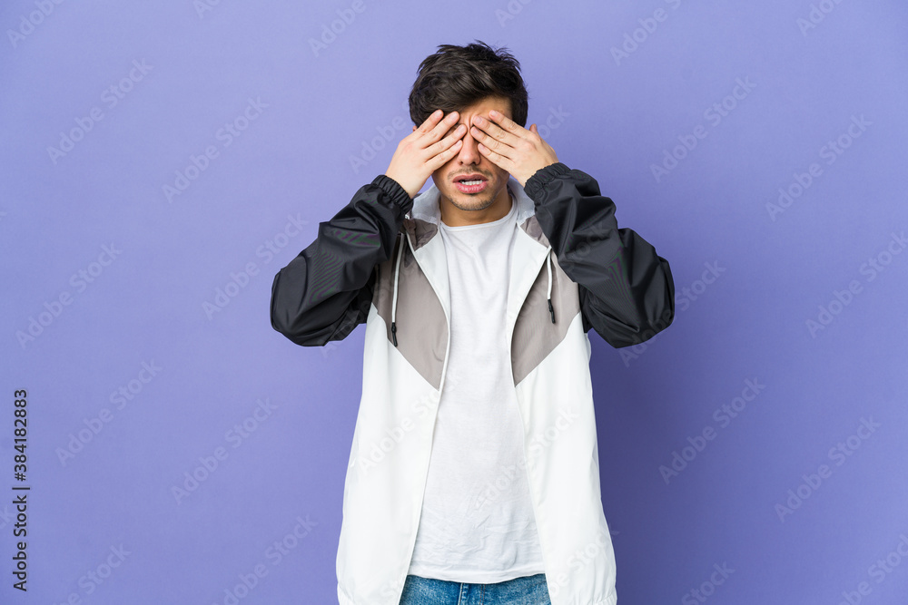 Young cool man afraid covering eyes with hands. Young cool man afraid covering eyes with hands.