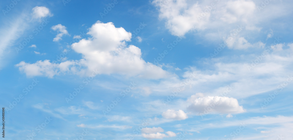 Fototapeta premium white fluffy flying clouds on blue panoramic sky, heaven background in high resolution