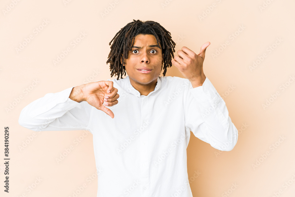 Young african american rasta man showing thumbs up and thumbs down, difficult choose concept Young african american rasta man showing thumbs up and thumbs down, difficult choose concept