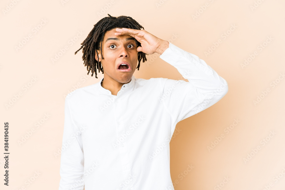 Young african american rasta man looking far away keeping hand on forehead. Young african american rasta man looking far away keeping hand on forehead.