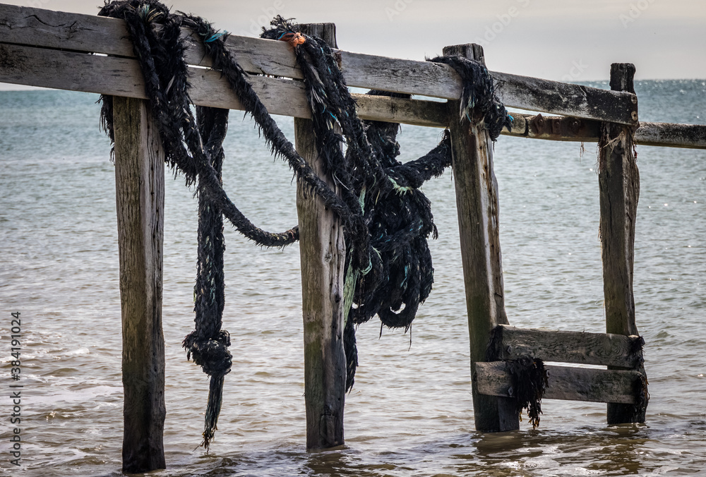 Obraz premium Old ropes attached to the pier