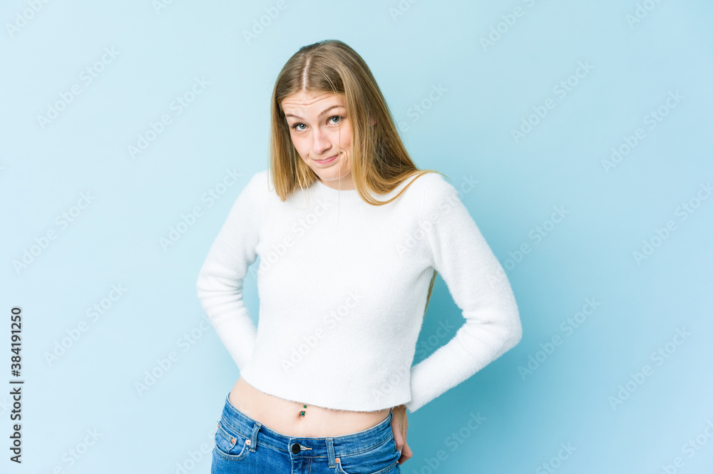 Young blonde woman isolated on blue background confused, feels doubtful and unsure. Young blonde woman isolated on blue background confused, feels doubtful and unsure.