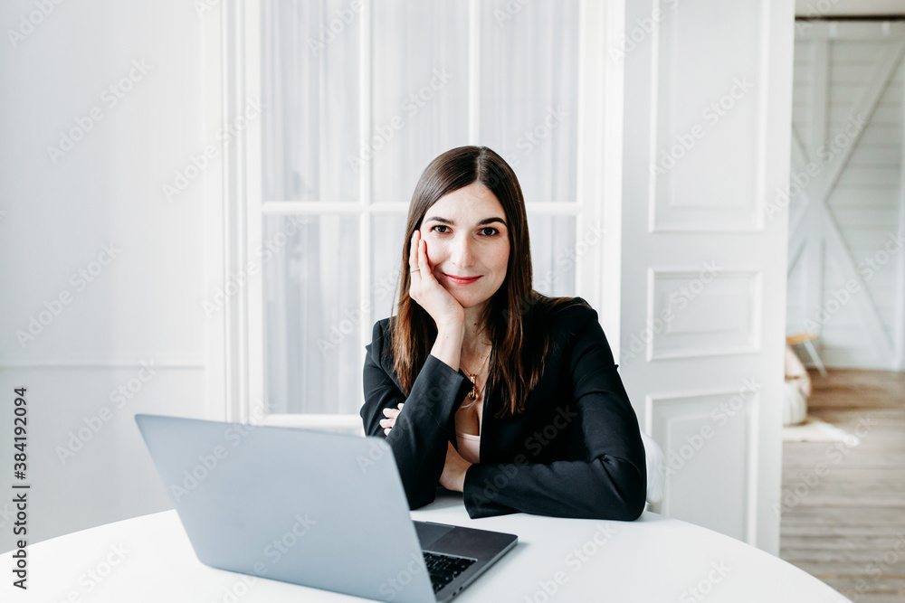Girl in dark clothes, suit working on a laptop, lawyer, consultant, specialist, work in the office and from home, Internet, communication with colleagues