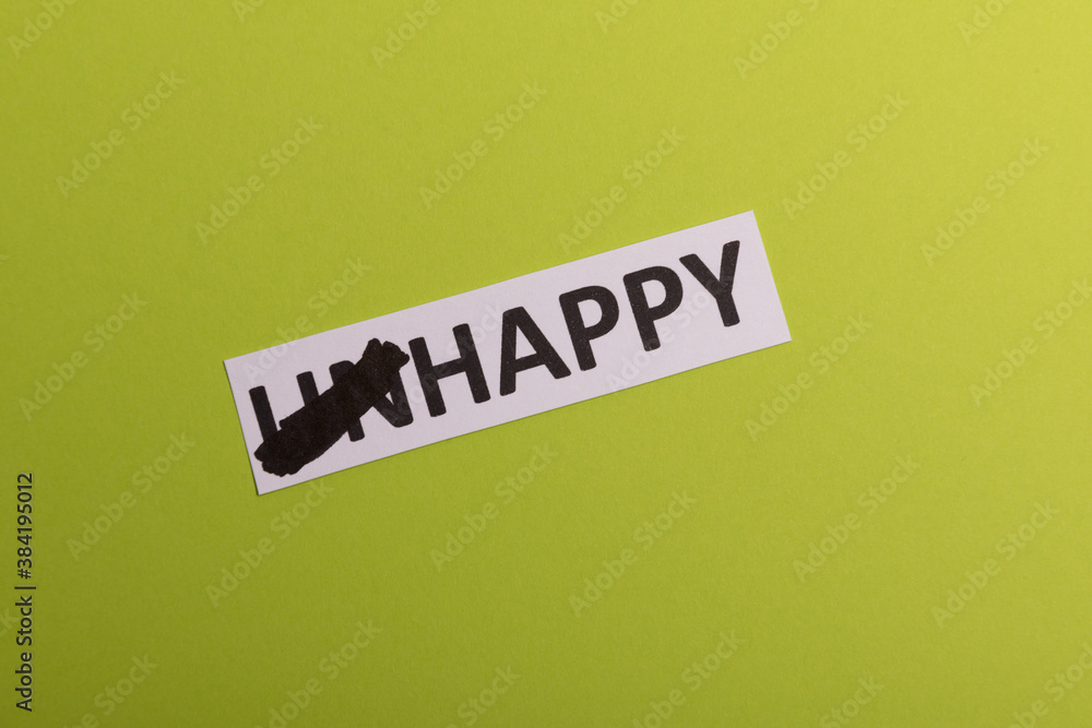card wit text unhappy, cutting word 'un' so it written 'happy'. Copy space. Lime background. Studio shoot card wit text unhappy, cutting word 'un' so it written 'happy'. Copy space. Lime background. Studio shoot