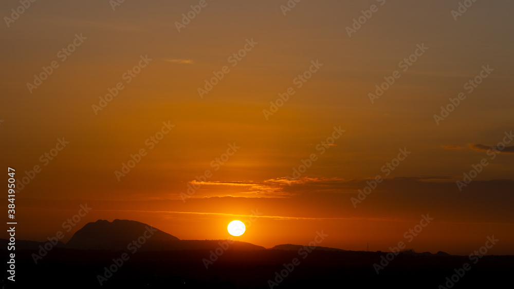 Silhouette of hills against beautiful golden hour sunset and beautiful orange sky