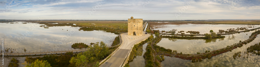 Aerial panoramic of the Carbonnière tower in the middle of the Camargue ponds, in Aigues-Mortes in the Gard, in Occitania, France