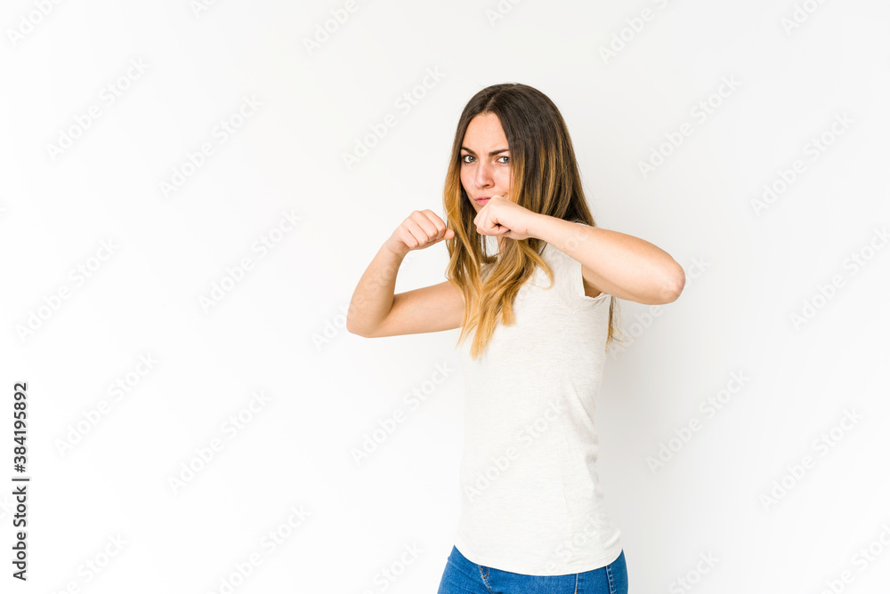 Young caucasian woman isolated on white background throwing a punch, anger, fighting due to an argument, boxing.