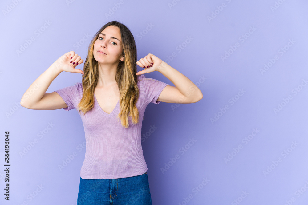 Young caucasian woman isolated on purple background feels proud and self confident, example to follow. Young caucasian woman isolated on purple background feels proud and self confident, example to follow.