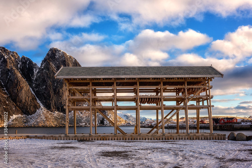 Traditional Norwegian wooden constructions for cod fish drying and red rorbu  fishing houses. Winter landscape on the Lofoten Islands  Reine  Northern Norway