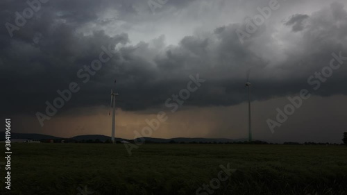 Windräder und Gewitterzelle mit dramatischer Struktur