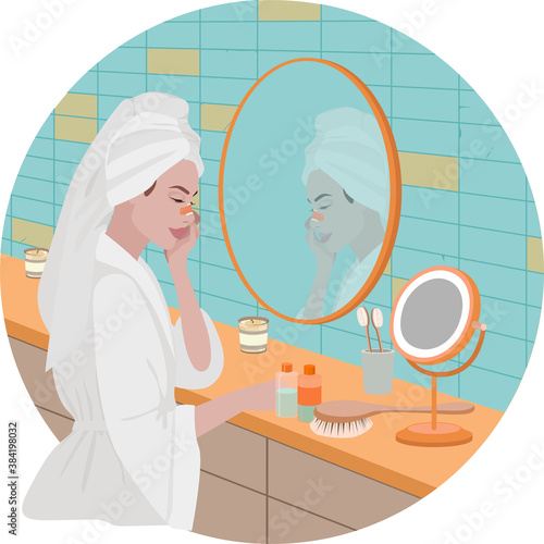 A girl in a robe and with a towel on her head removes the fixative from her nose after the rhinoplasty procedure.bandage on the nose