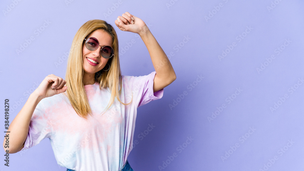 Naklejka premium Young blonde caucasian woman celebrating a special day, jumps and raise arms with energy.
