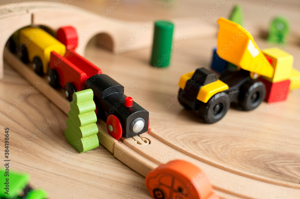 Colored wooden blocks toy. Wooden train and on a railway and other machines in composition. Colored wooden blocks toy. Wooden train and on a railway and other machines in composition.