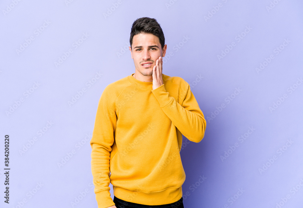 Young caucasian man isolated on purple background having a strong teeth pain, molar ache. Young caucasian man isolated on purple background having a strong teeth pain, molar ache.