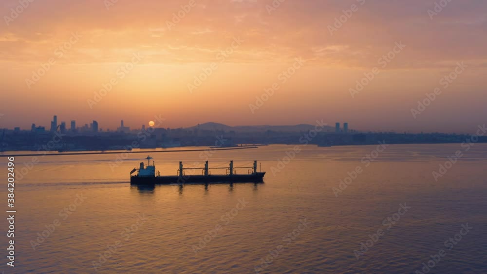 Cargo ship sails along the Bosphorus or Bosporus (also is known as Strait of Istanbul) at sunset. Aerial side view Cargo ship sails along the Bosphorus or Bosporus (also is known as Strait of Istanbul) at sunset. Aerial side view