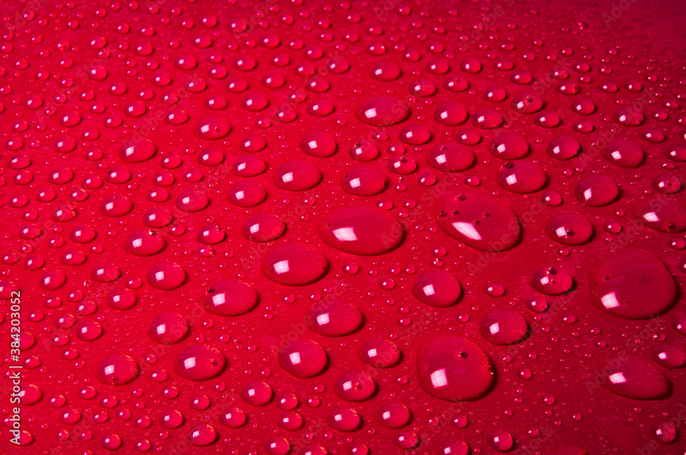 Drops of water on a red glass texture background Drops of water on a red glass texture background