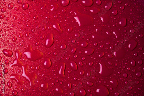 Drops of water on a red glass texture background