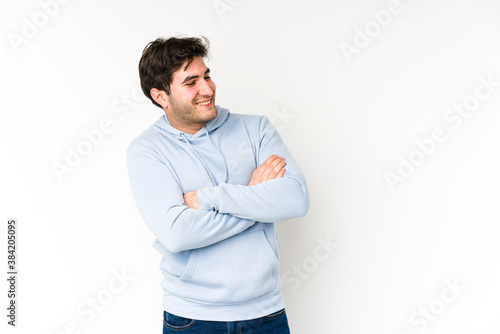 Young man isolated on white background smiling confident with crossed arms.