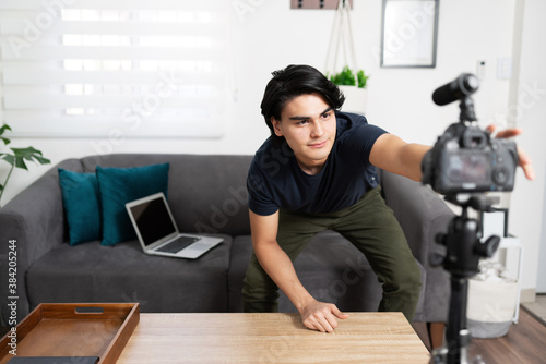 Influencer pushing record button at home