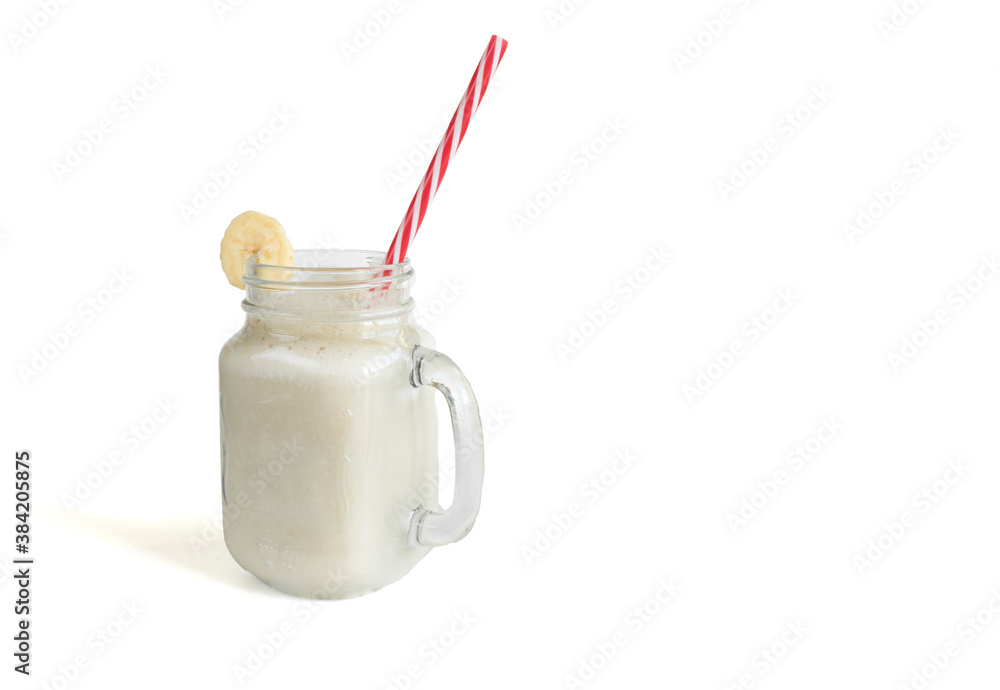Fresh banana smoothie in a glass jar with a straw, on a white isolated background. Healthy food. Vegetarian food. Fresh banana smoothie in a glass jar with a straw, on a white isolated background. Healthy food. Vegetarian food.