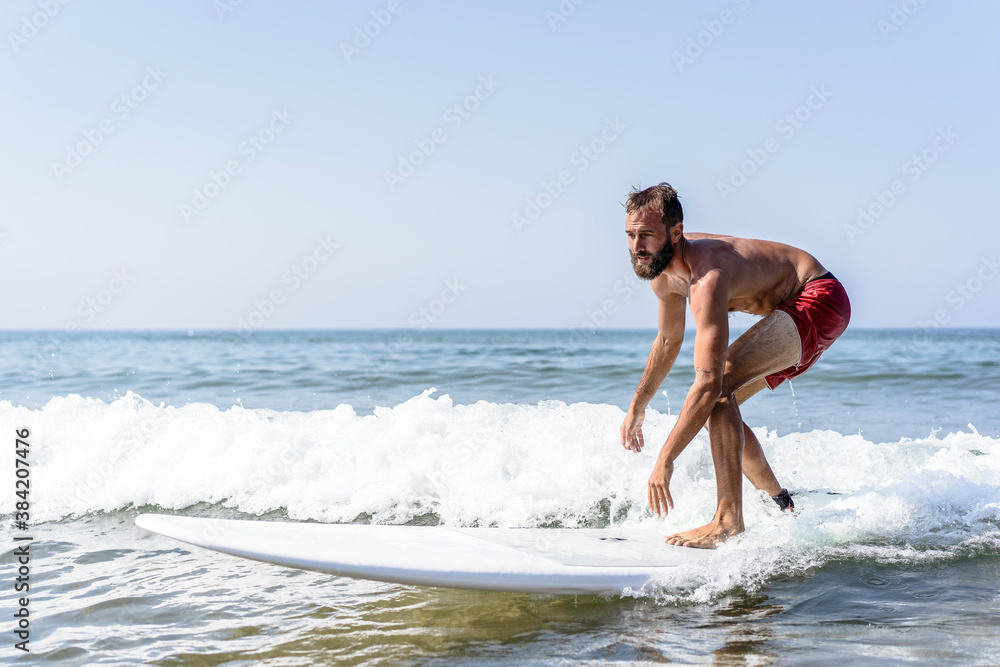 Hipster man surfing with a longboard on the waves - Fit guy training with a surfboard on a slightly rough sea - Water sport, fitness and balance concept - Copy space for text, main focus on the face Hipster man surfing with a longboard on the waves - Fit guy training with a surfboard on a slightly rough sea - Water sport, fitness and balance concept - Copy space for text, main focus on the face