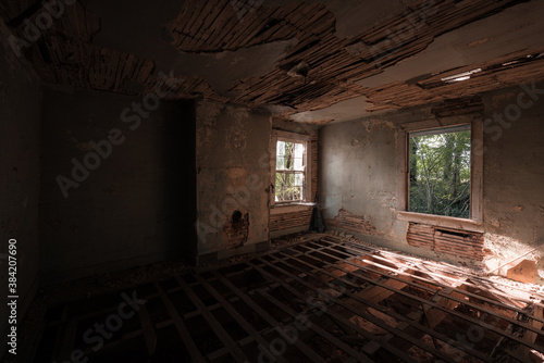 This is an interior of a bedroom that has been stripped of its flooring and is down to its wood joists at a long-abandoned house in Virginia. © Sherman Cahal