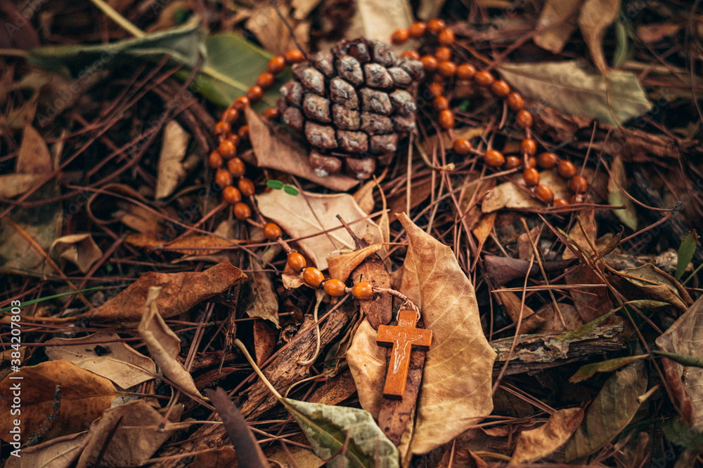 rosary lying on an autumn blanket of golden leaves. Autumn style and mood. vintage autumn photo