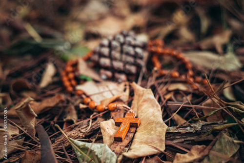 rosary lying on an autumn blanket of golden leaves. Autumn style and mood. vintage autumn photo