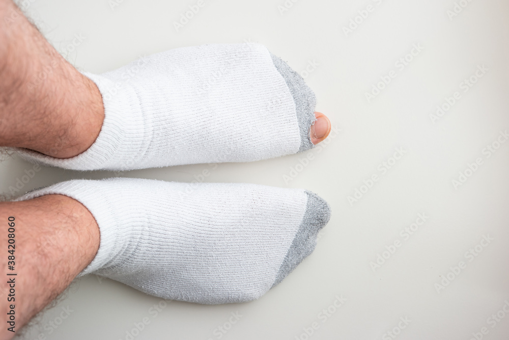 Caucasian male toe sticking out of worn out short white socks with hole top view Caucasian male toe sticking out of worn out short white socks with hole top view