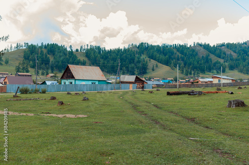 landscape russian village in mountain  rocks summer. Mountain nature, clean air.  Picturesque authentic village  surrounded by mountains. Small houses and gardens in a valley  background from nature © MariyaSokolova