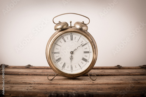 Vintage Metal Alarm Clock on Old Wooden Trunk