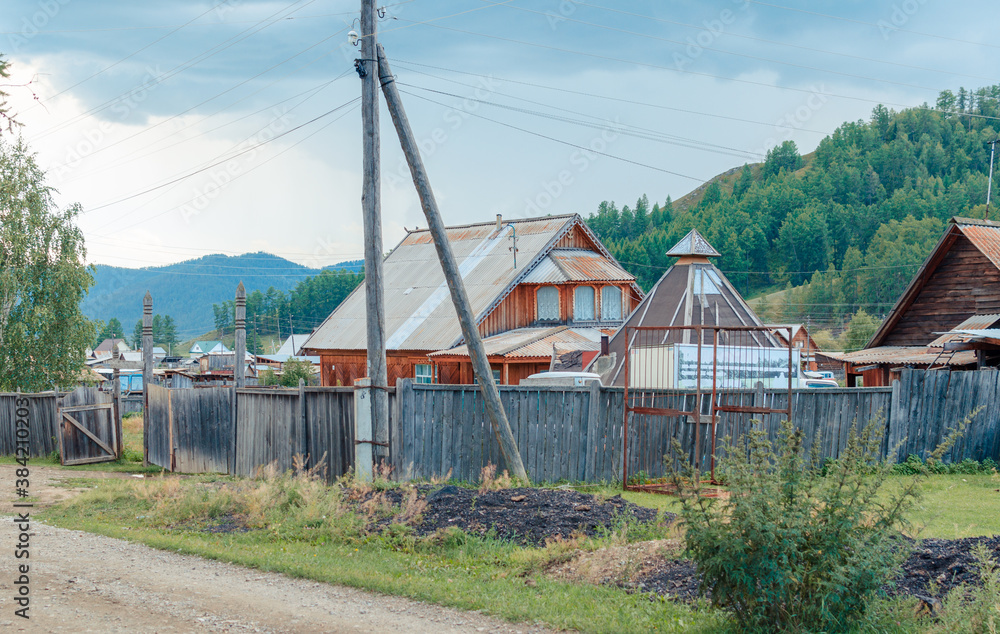 landscape russian village in mountain rocks summer. Mountain nature, clean air. Picturesque authentic village surrounded by mountains. Small houses and gardens in a valley background from nature landscape russian village in mountain rocks summer. Mountain nature, clean air. Picturesque authentic village surrounded by mountains. Small houses and gardens in a valley background from nature