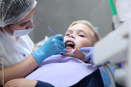 Prevention of caries in children.Oral hygiene. A child's dentist cleans the child's teeth. Photo in the interior on a light background. Pediatric dentistry.