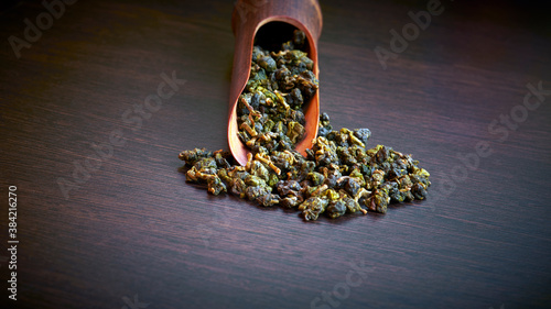 фотографія Taiwan oolong tea Li shan with wooden spoon on  dark grey background