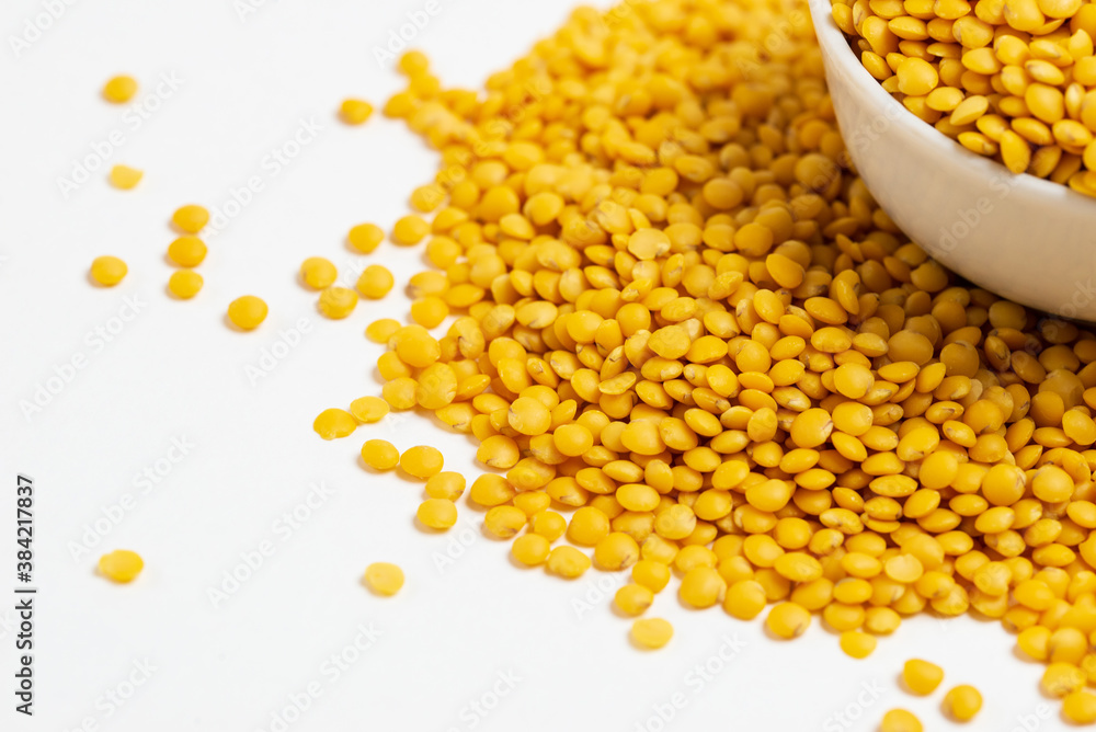 Yellow lentils in a white bowl on a white background Yellow lentils in a white bowl on a white background