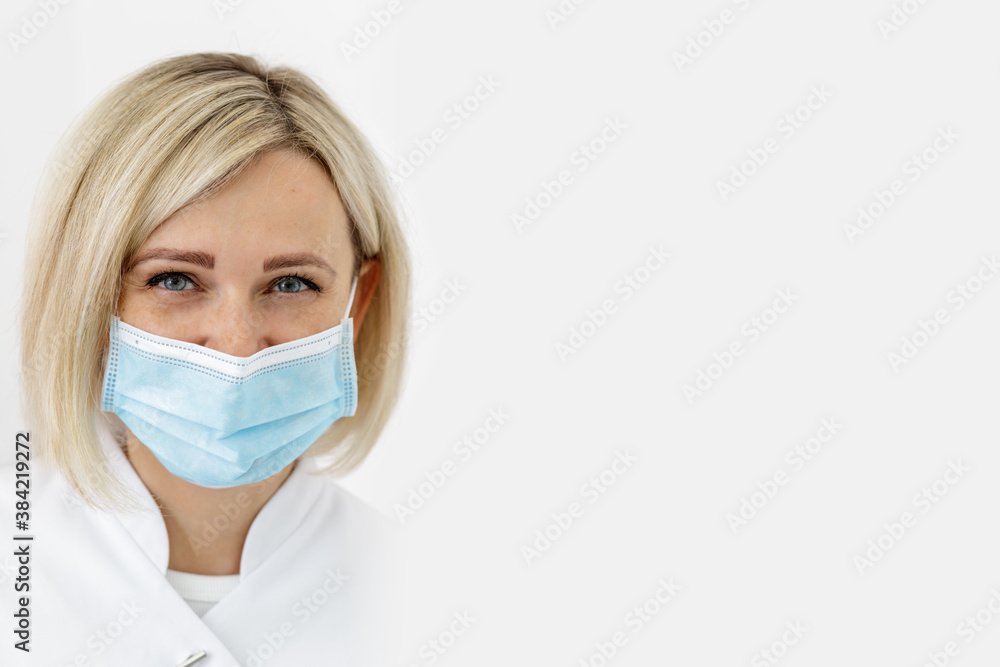 Portrait of pretty smiling medical female specialist in a mask Portrait of pretty smiling medical female specialist in a mask