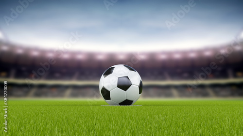 Soccer ball or football in the middle of the field with the stands blurred out in the background