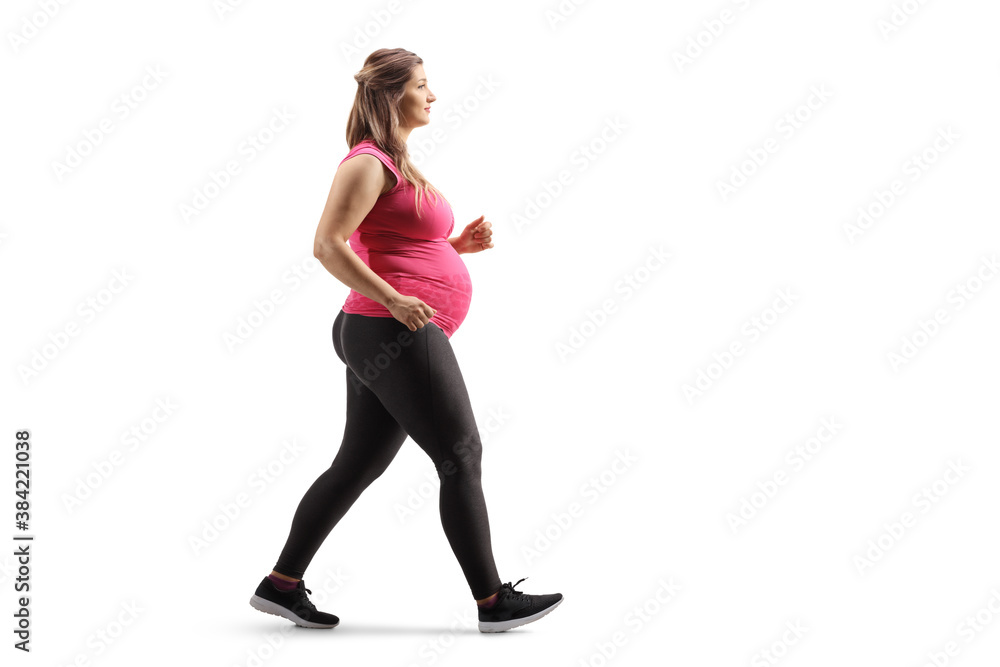 Full length profile shot of a pregnant woman in sportswear walking Full length profile shot of a pregnant woman in sportswear walking