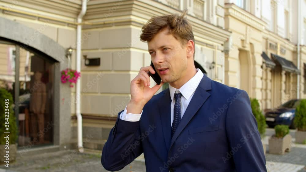 Portrait man talking cellphone at street. Businessman using smartphone outdoors