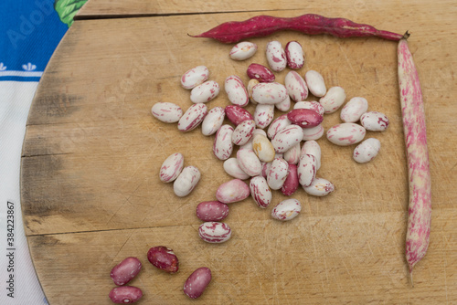 Borlotti beans peeled on wooden cutting board.