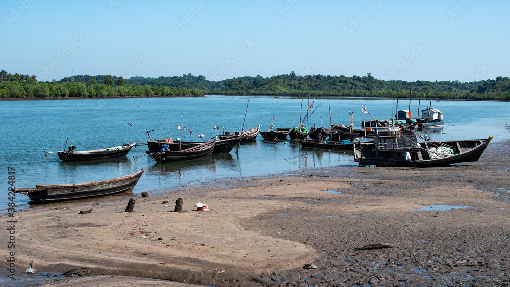 Wooden fishing boats by the river during low tide, Chaung Thar, Myanmar